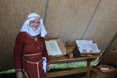 A scribe standing by examples of her work