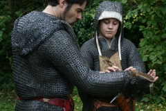 Squire helping knight to arm